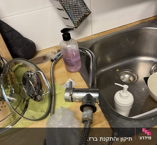 ברז מטבח מפורק ליד כיור עם צינור גמיש